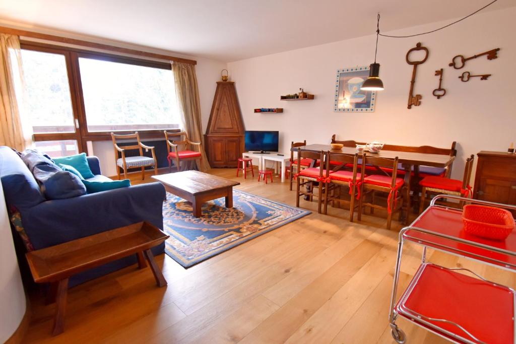 a living room with a couch and a dining room at Appartamento al Passo in Madonna di Campiglio