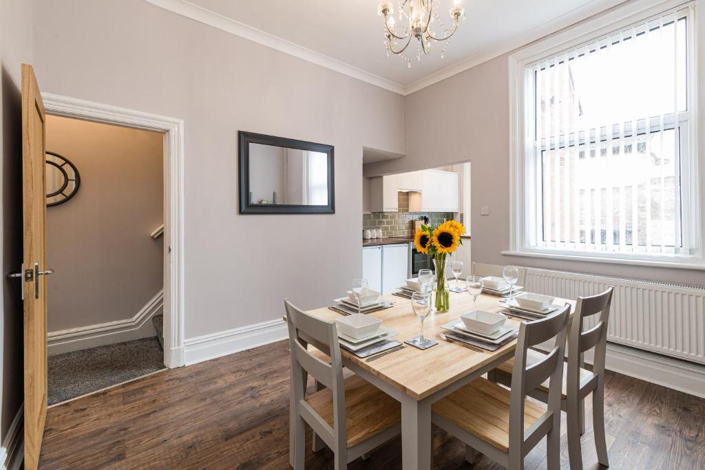 a dining room with a wooden table and chairs at Carnarvon House - Wi-Fi & Parking Contractors in Preston