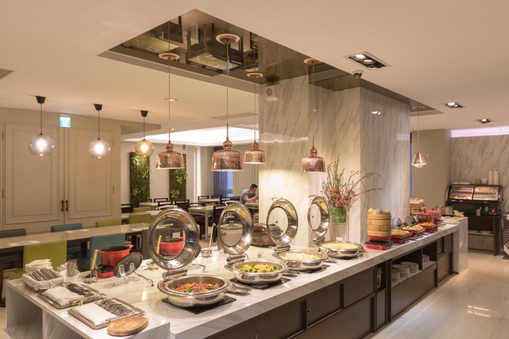 a kitchen with many plates of food on a counter at Just Enjoy Business Hotel in Tainan