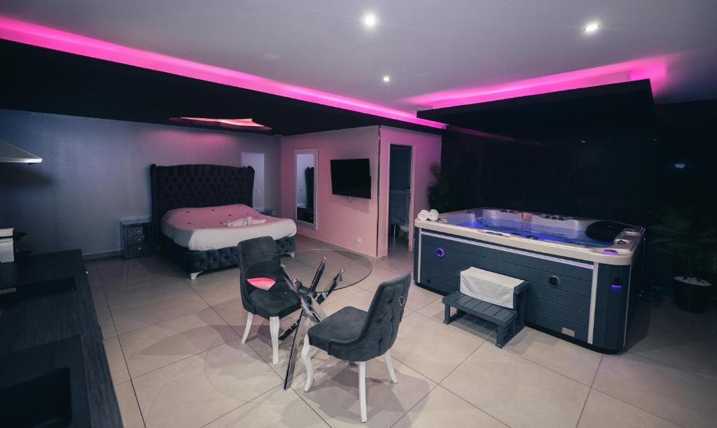 um quarto com uma cama, uma secretária e cadeiras em Love night Marseille jacuzzi em Le Rove