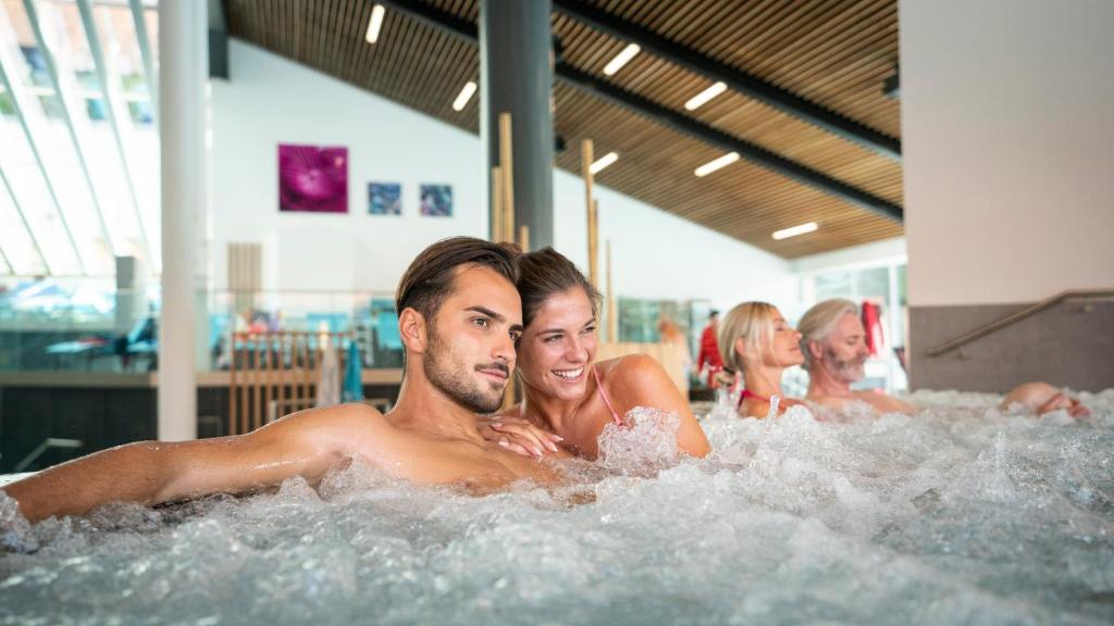 un hombre y una mujer en un jacuzzi en Appartement-Haus Blumenhof, en Bad Griesbach