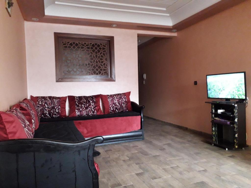 sala de estar con sofá y TV de pantalla plana en Noure Riyad, en Rabat