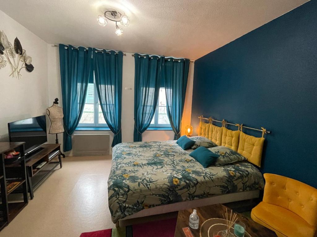 1 dormitorio con paredes azules, 1 cama y 1 silla en Studio cosy confortable en centre ville, en Verdún