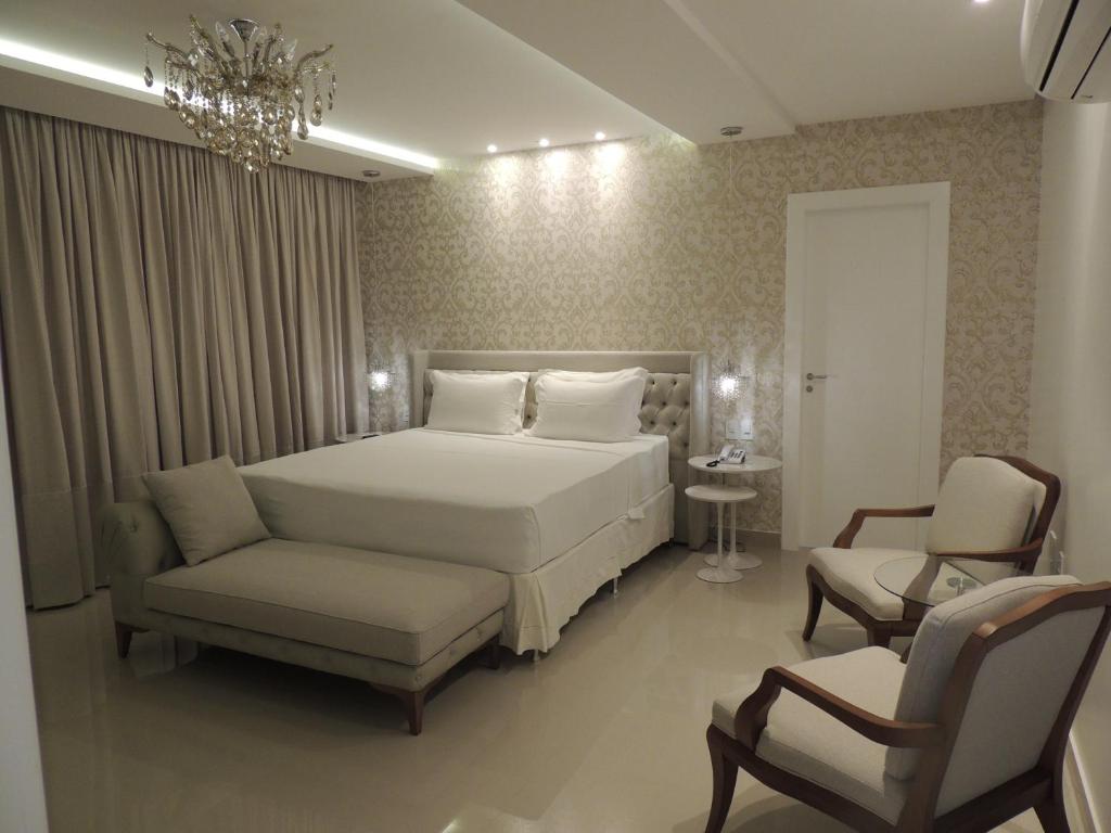 イタペルナにあるStar Hotelのベッドルーム1室(ベッド1台、ソファ、椅子付)