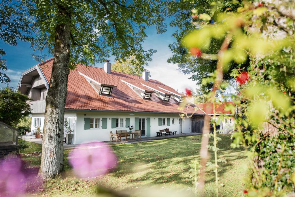 uma casa branca com um telhado vermelho em Ferienhaus BERGEBLICK DELUXE em Bad Tölz