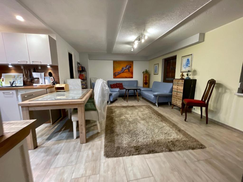eine Küche und ein Wohnzimmer mit einem Tisch und Stühlen in der Unterkunft Ferienwohnung im Schwarzwaldhaus in Ebersbach