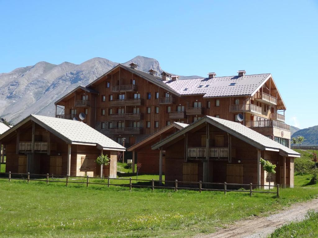 a group of buildings with mountains in the background at Residence Le Hameau du Puy by Actisource in Le Dévoluy