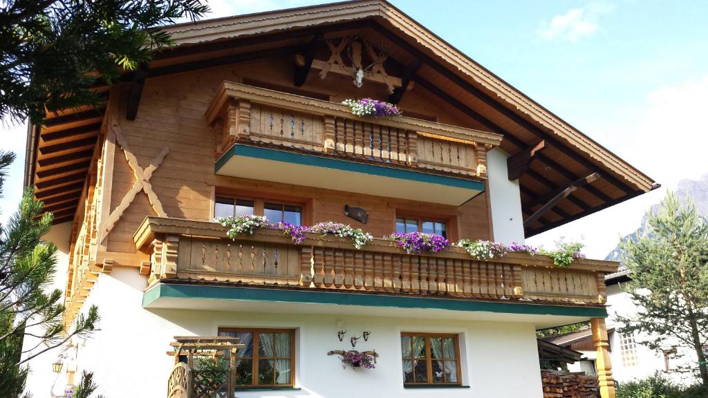 una casa con un balcón con flores. en Appartements Zugspitztraum, en Ehrwald