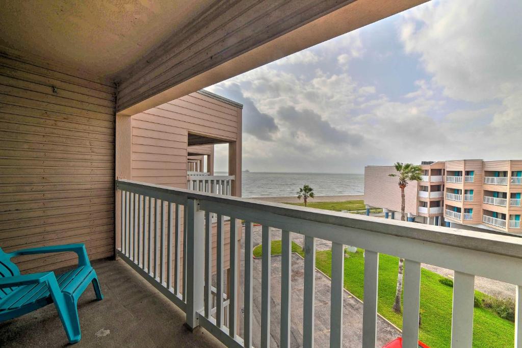 a balcony with a blue chair and a view of the ocean at Sun-Soaked Texas Condo with North Beach Access! in Corpus Christi