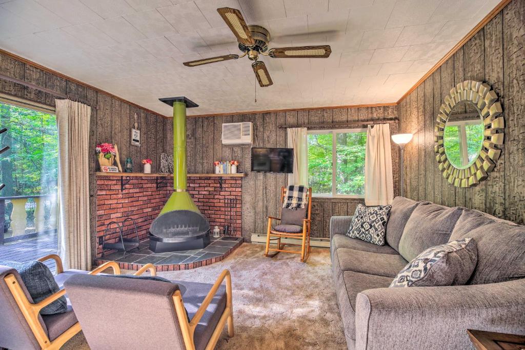 a living room with a couch and a fireplace at Cozy Adirondacks Cabin Walk to Lake Eaton! in Jay