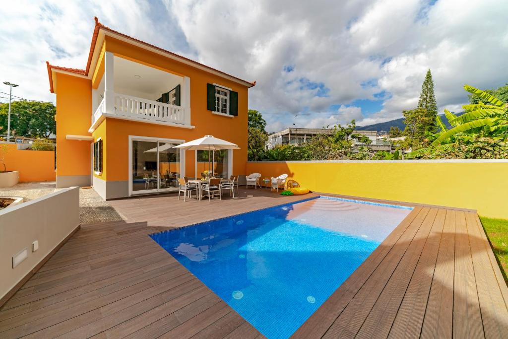 a villa with a swimming pool and a house at The Yellow House by LovelyStay in Funchal