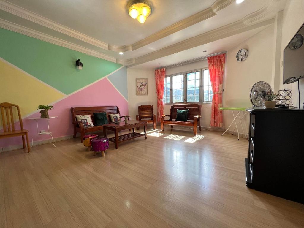 uma sala de estar com paredes coloridas e pisos em madeira em Unicorn Homestay @ Cameron Highland em Tanah Rata