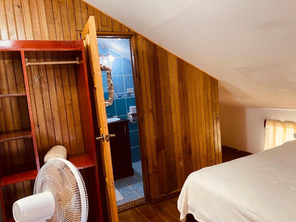 a room with a bed and an open door with a fan at Hotel Caribbean View in Bastimentos