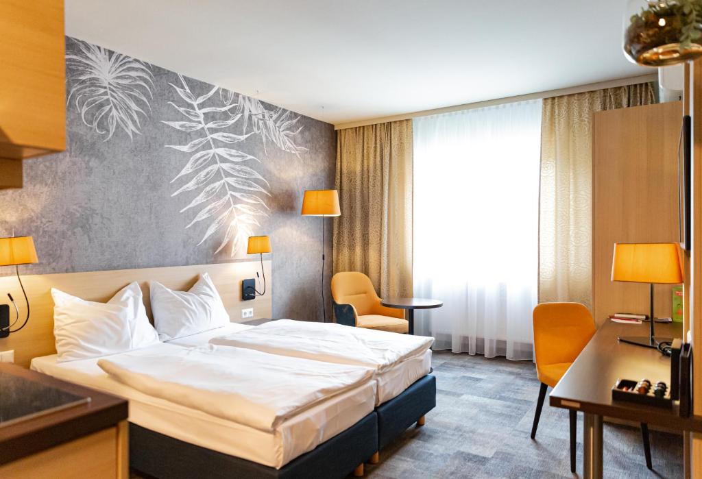 um quarto de hotel com uma cama e uma secretária em Hotel Das Himberg em Himberg