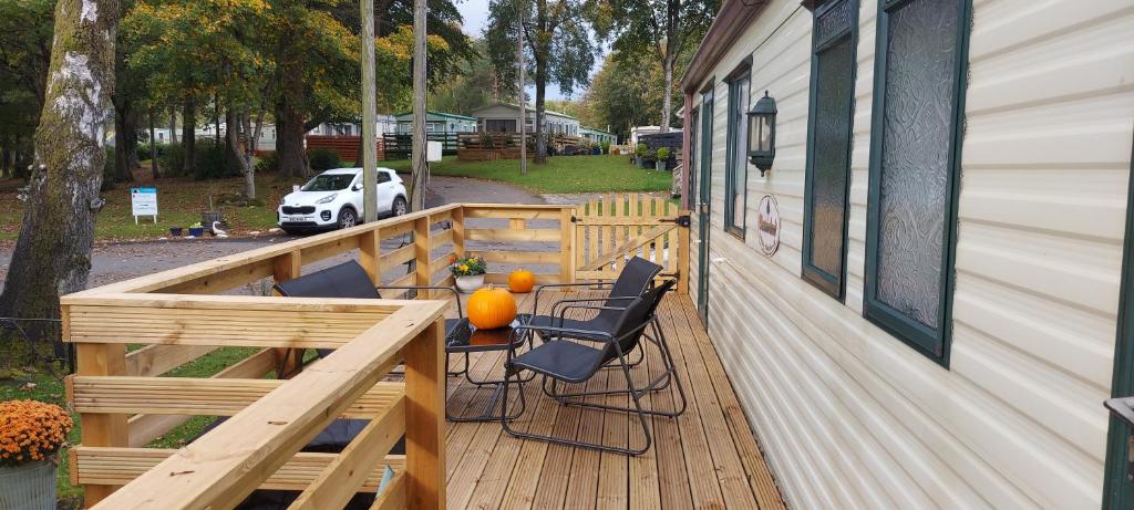 un porche con mesa y sillas en una casa en Westmorland 32 caravan, en Ballantrae