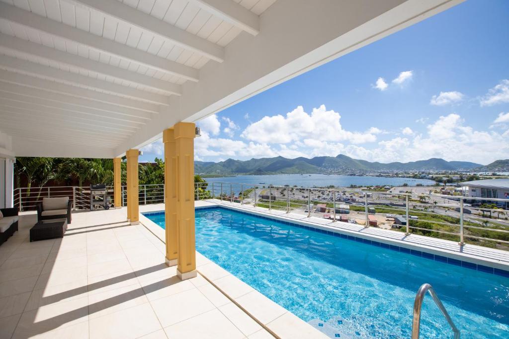 uma vista a partir da varanda de uma casa com piscina em Reflection Z 5 Star Villa em Maho Reef