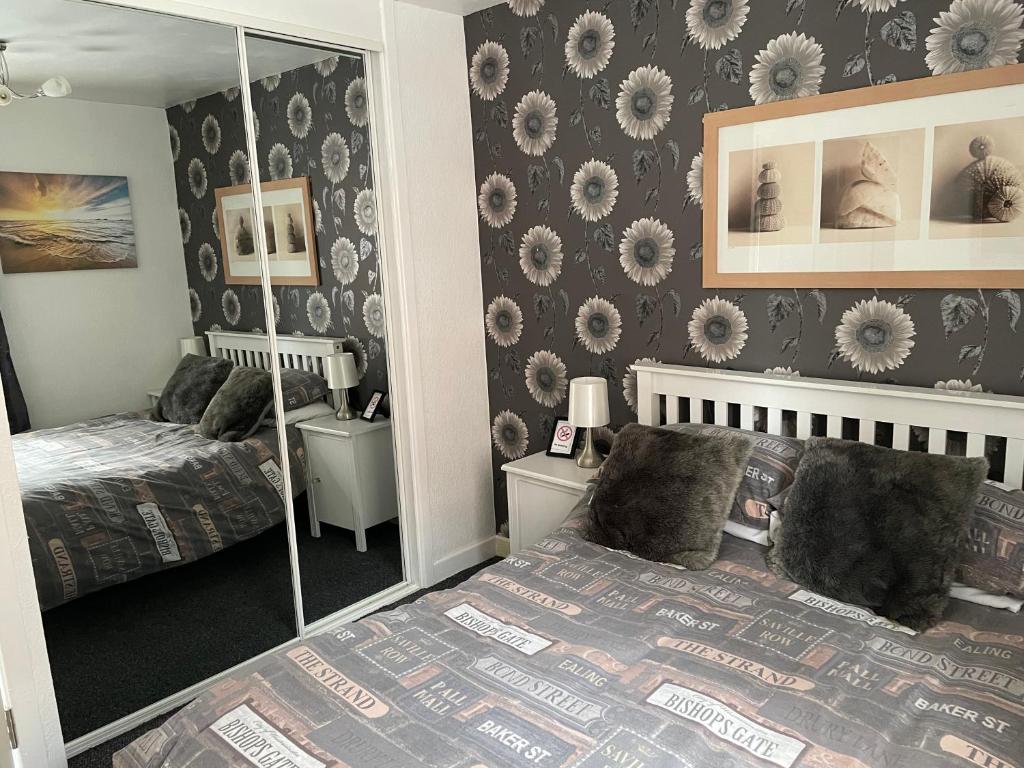 a bedroom with two beds and a mirror at 2 Bed Flat - Sleeps 3 - Parking - Wifi in Morecambe