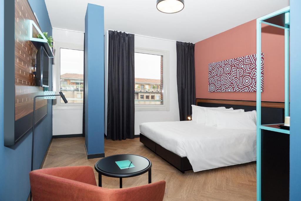 um quarto de hotel com uma cama e uma cadeira em CX Turin Regina Student&Explorer Place em Turim