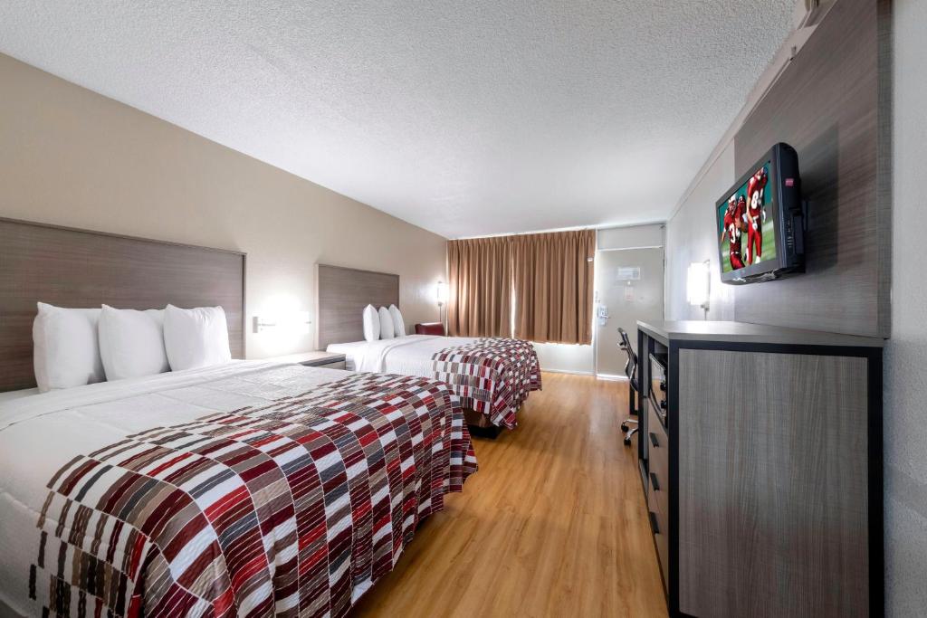 Habitación de hotel con 2 camas y TV de pantalla plana. en Red Roof Inn Charlottesville, en Charlottesville