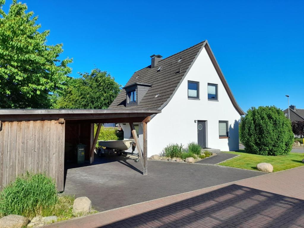 a white house with a patio and a grill at Direkter Blick auf´s Wasser in Fahrdorf