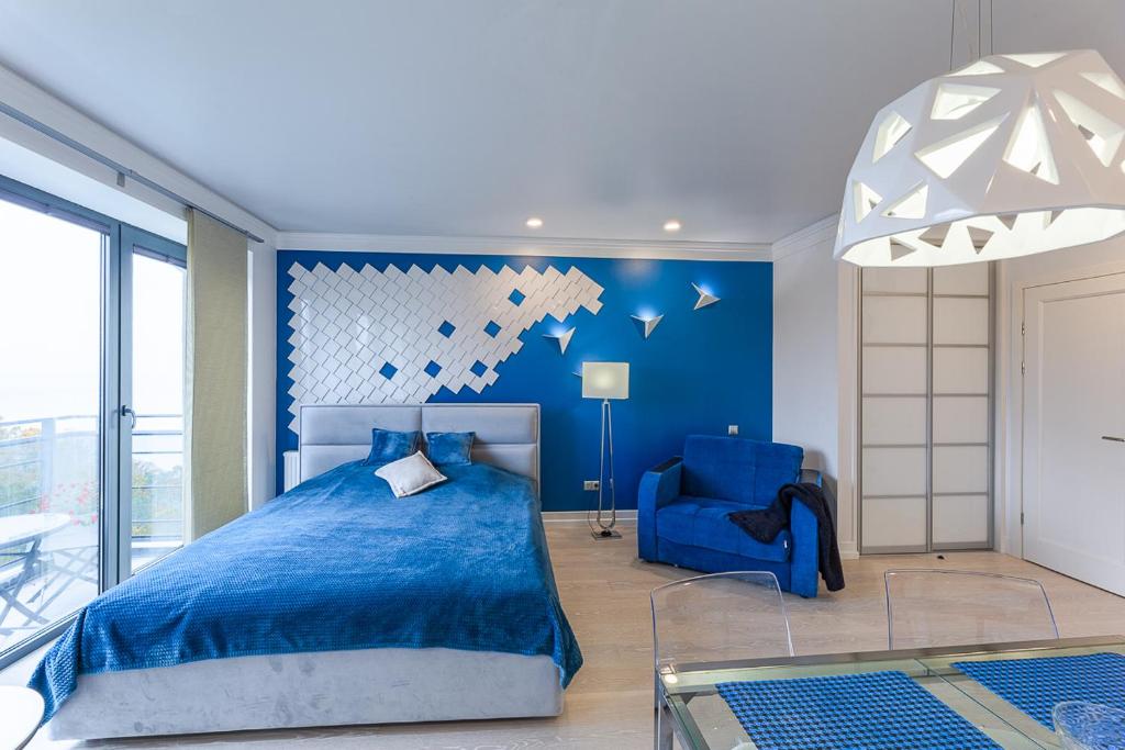 スヴェトロゴルスクにあるBaltic Luxury-52 with Sea viewのベッドルーム(青いベッド1台、青い椅子付)