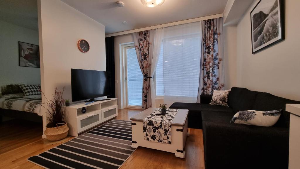 a living room with a couch and a tv at First Class-Annankatu in Pori