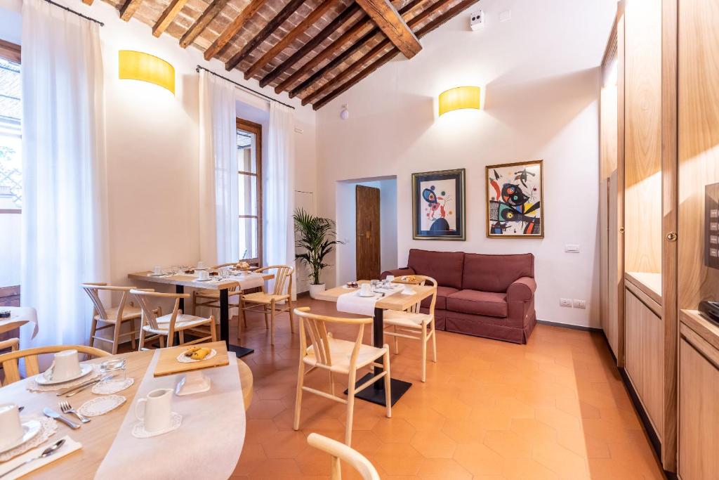 - un restaurant avec des tables, des chaises et un canapé dans l'établissement La Casa del Ghiberti B&B, à Florence