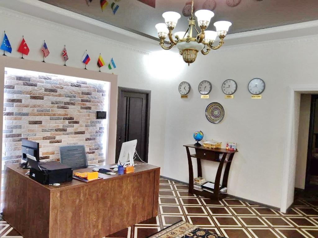 an office with a desk and clocks on the wall at Chinara Guest House Airport in Tashkent