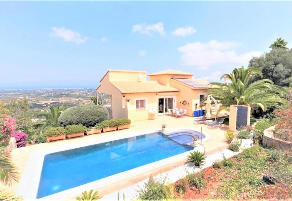 a villa with a swimming pool in front of a house at Luxury Villa at La Sella Resort in Pedreguer