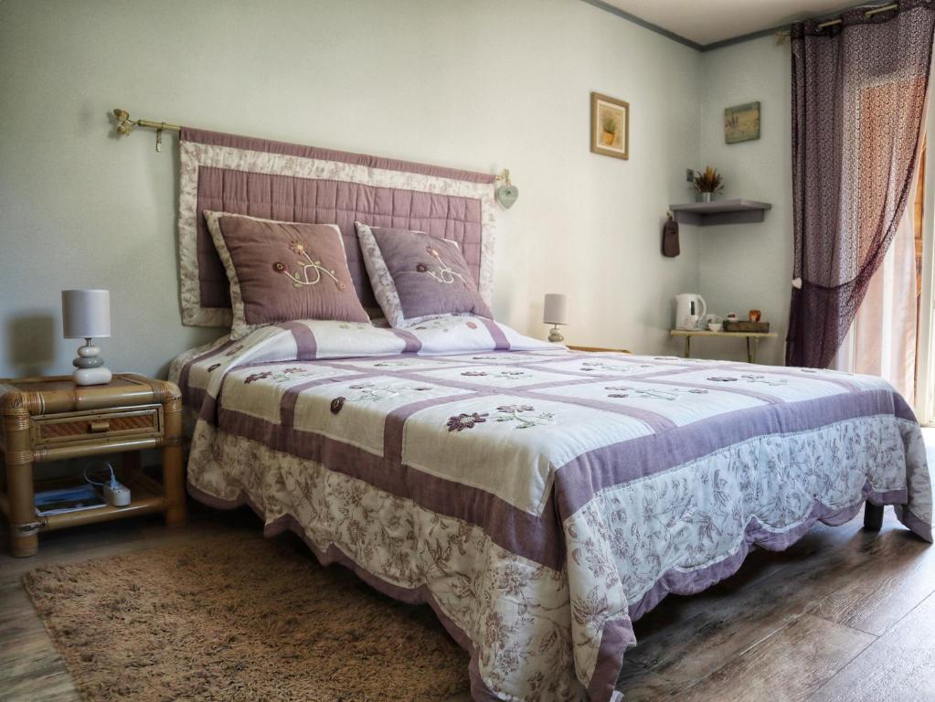 ドラギニャンにあるLe Jardin des Selvesのベッドルーム1室(大型ベッド1台、紫色の掛け布団付)