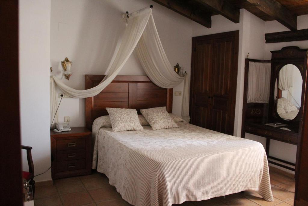 a bedroom with a bed with a canopy and a dresser at Hotel La Villa in Requena