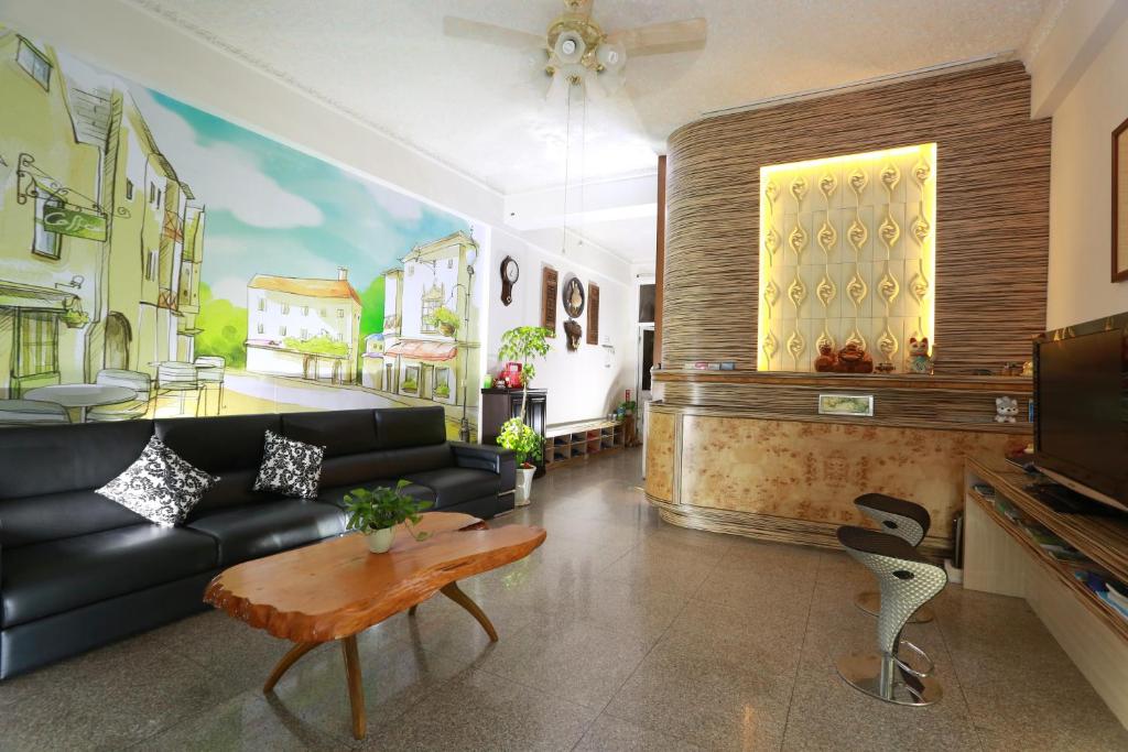 - un salon avec un canapé noir et une table dans l'établissement Xiang Heng House, à Luodong