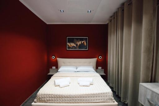 sypialnia z dużym łóżkiem w czerwonej ścianie w obiekcie Novs Hotel Rooms w Gjirokastrze