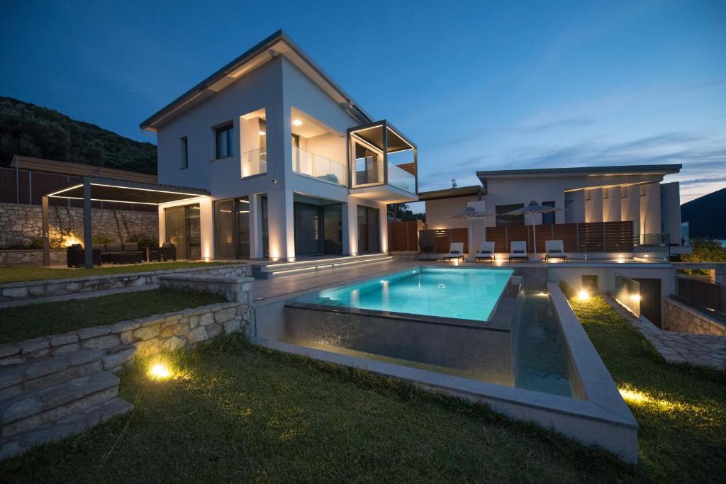 Mrs Grey Luxury Villa في ميغانيسي: بيت فيه مسبح بالليل