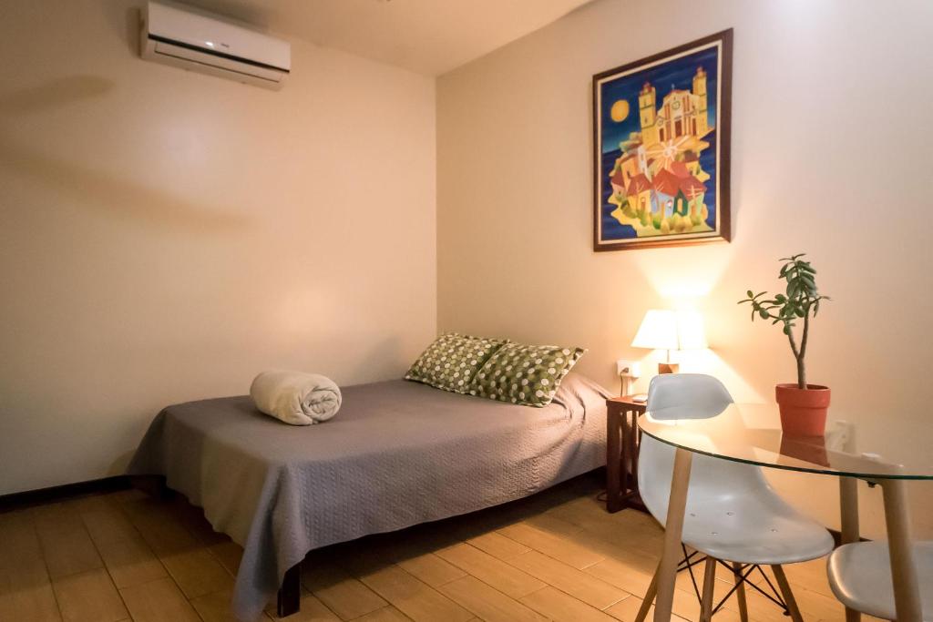 Cette petite chambre comprend un lit et une table. dans l'établissement Terida Airport B&B, à Alajuela
