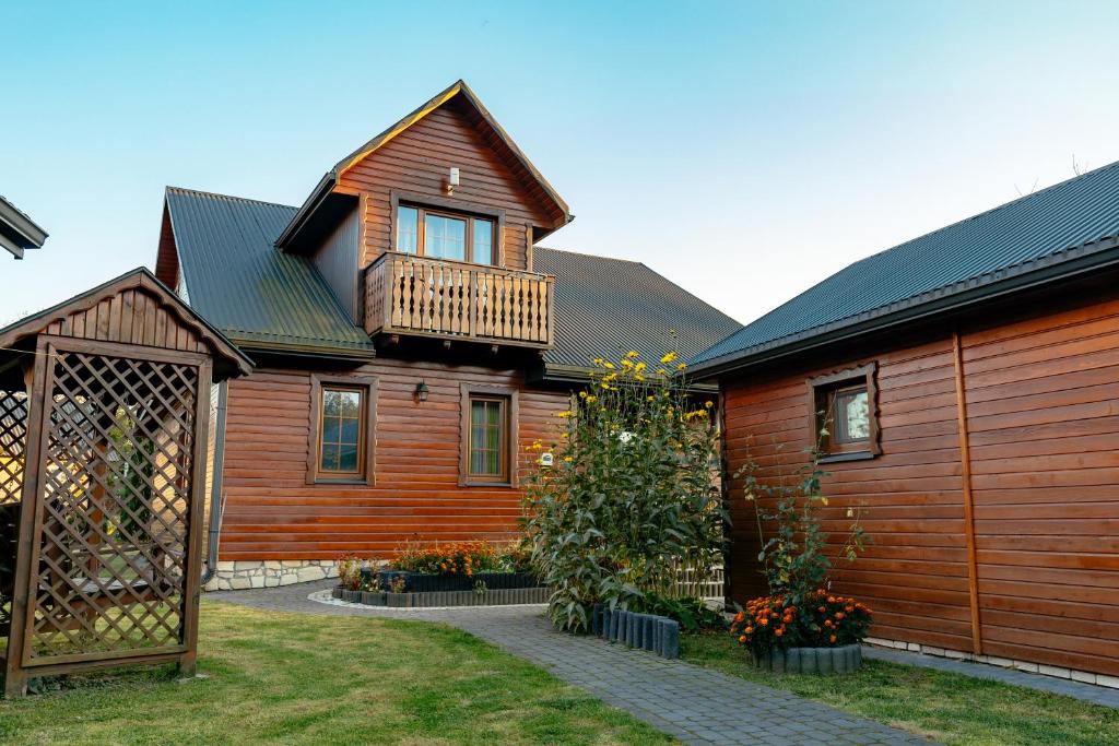a wooden house with a balcony on top of it at Domek Majowy ze strefą Wellness in Susiec