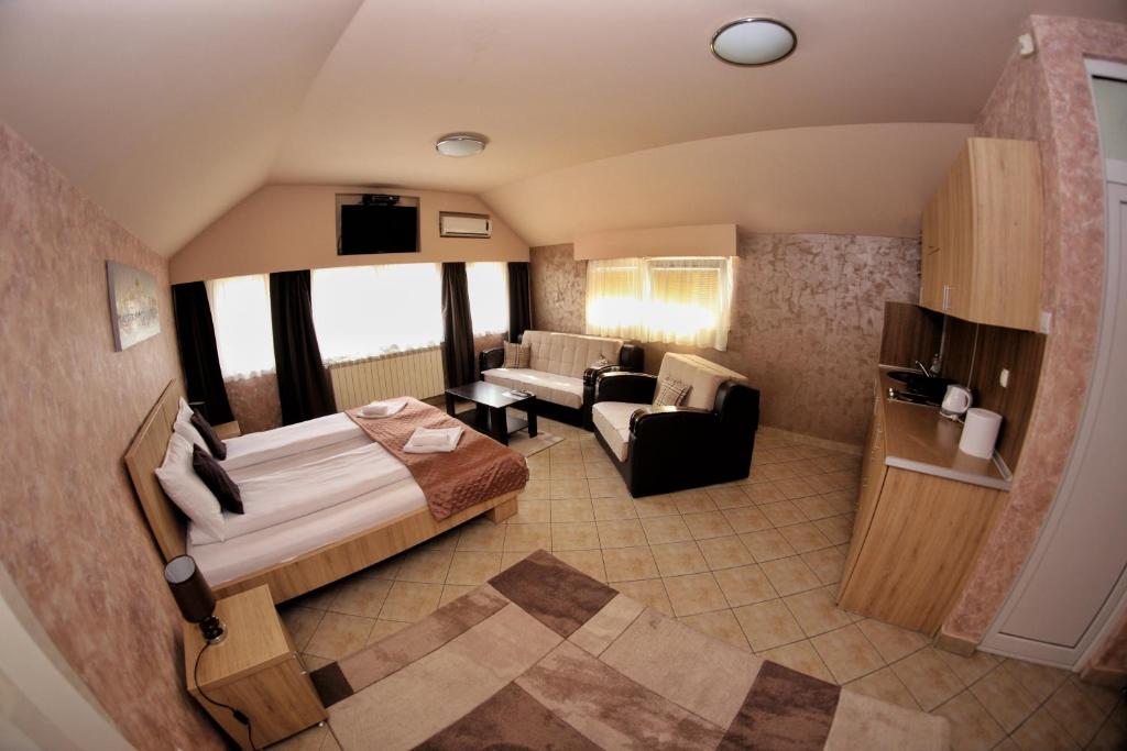 a hotel room with a bed and a couch at Apartmani Zecevic Niksic in Nikšić