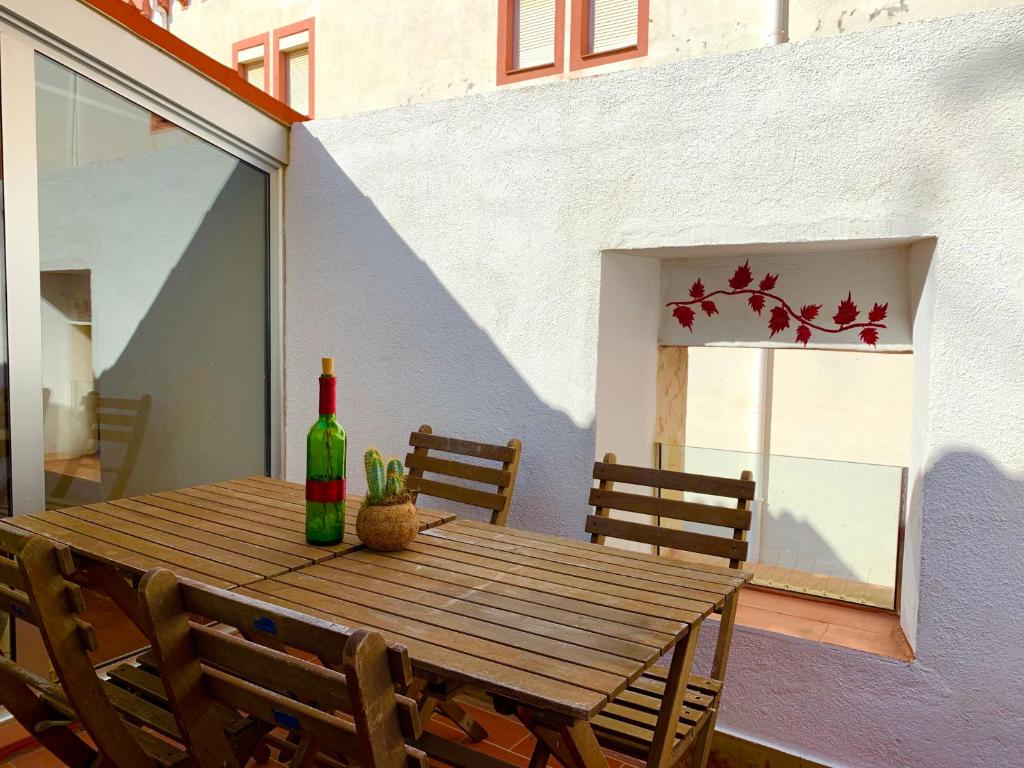 una mesa de madera con una botella de vino y un cactus en Atico junto a la Catedral, en Tarragona