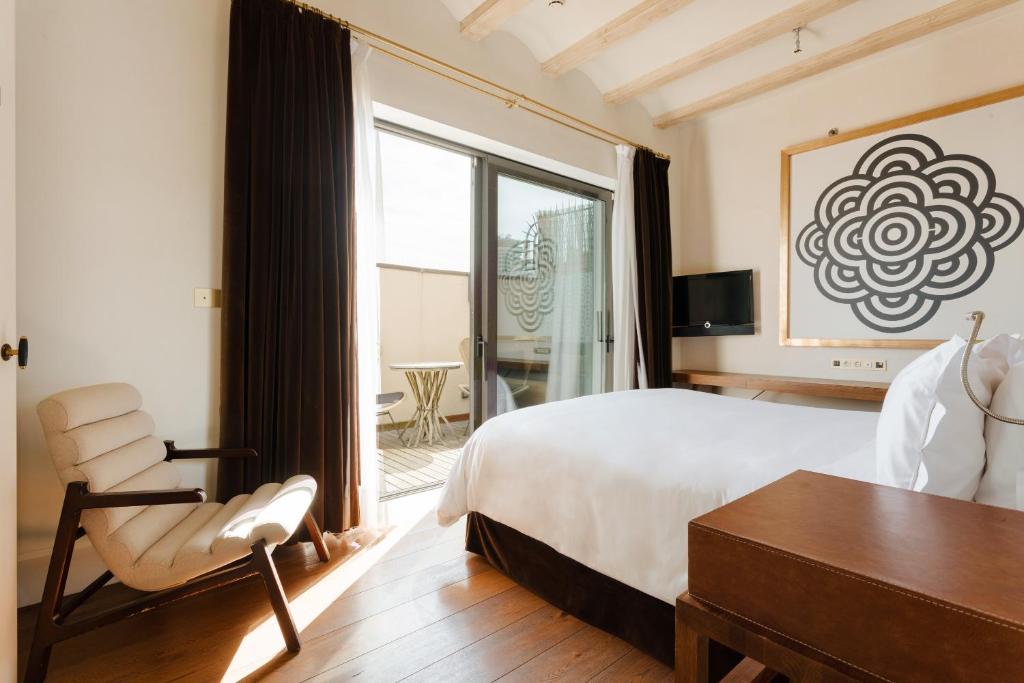 una camera con un letto e una sedia e una finestra di DO Plaça Reial powered by Sonder a Barcellona