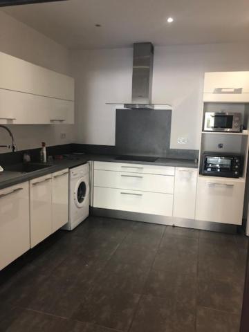 a kitchen with white cabinets and a washer and dryer at T3 moderne et spacieux à BASTIA in Bastia
