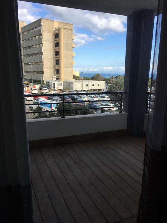 a balcony with a view of a parking lot with cars at T3 moderne et spacieux à BASTIA in Bastia