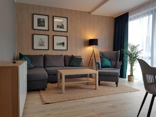 a living room with a couch and a coffee table at Apartament Triventi 88 z Widokiem na Śnieżkę - 5D Apartamenty in Karpacz