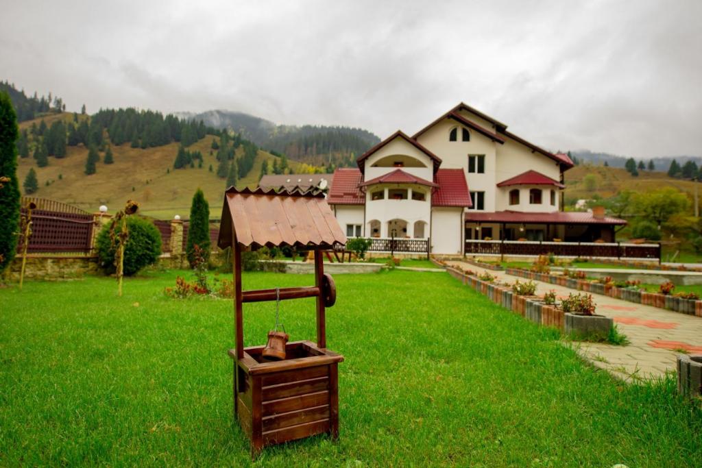 a large house in a field of green grass at Pensiune Domeniul Stanca in Vatra Dornei