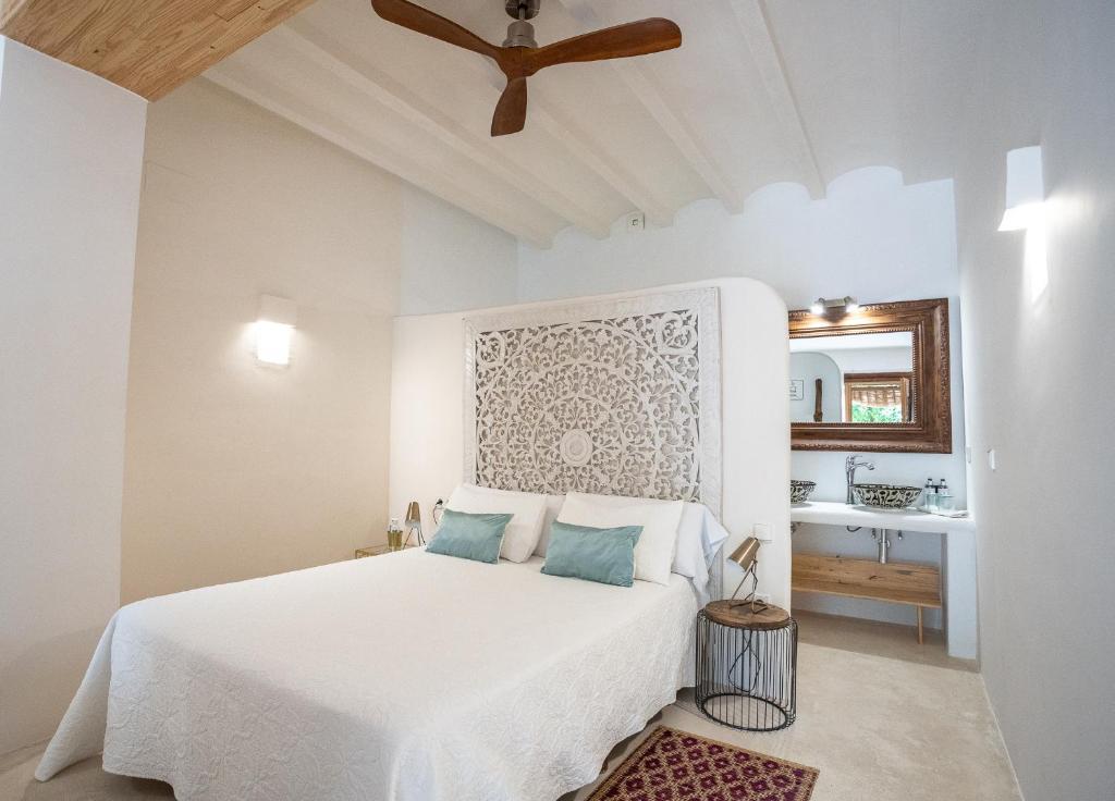 a bedroom with a white bed with a ceiling fan at Boho Suites Denia in Denia