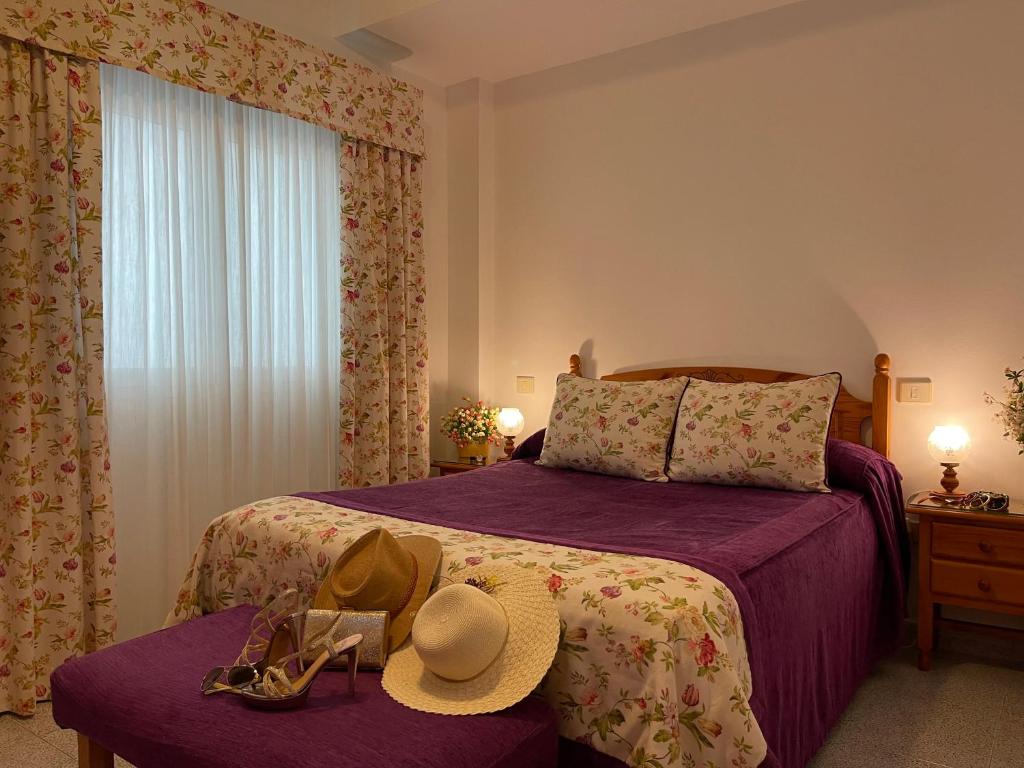 1 dormitorio con 1 cama con sombrero y gafas en EmyCanarias Holiday Homes Vecindario, en Vecindario