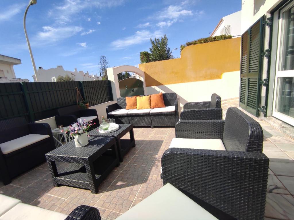 a patio with couches and a table and chairs at Vila Magna near The Strip with BBQ, AC, Balcony, Parking, 4 TVs and Free wifi in Albufeira