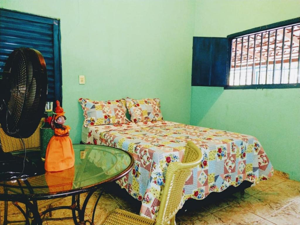 um quarto com uma mesa e uma cama com uma mesa de vidro em Pousada Joao & Maria em Pirenópolis