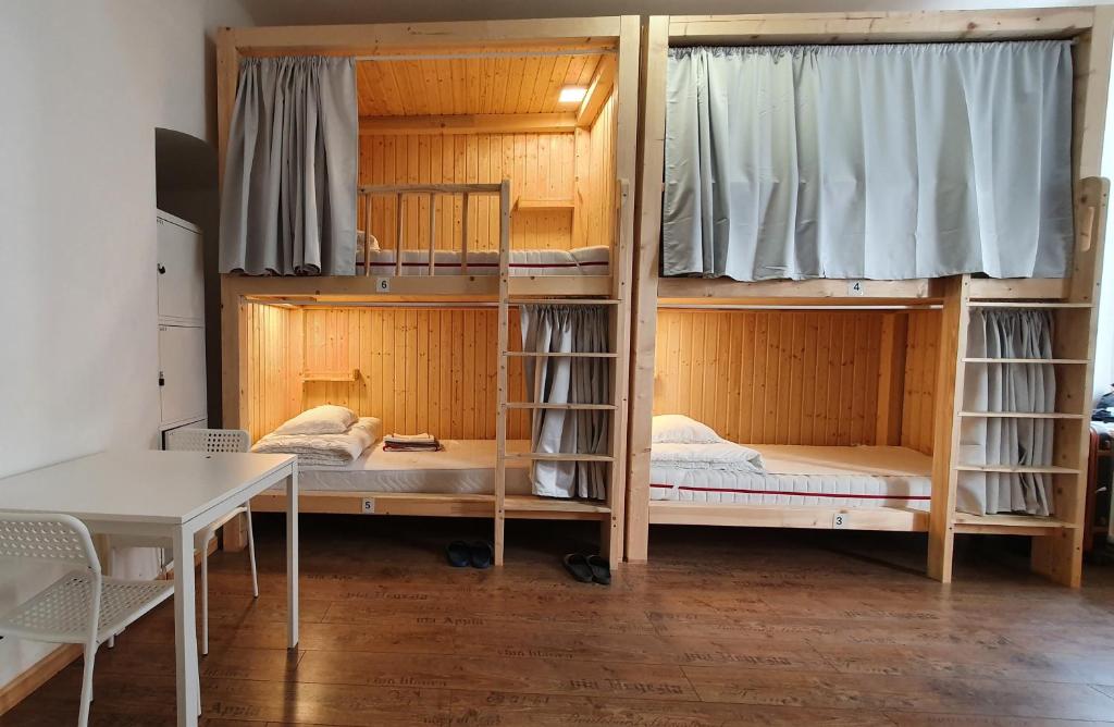 a room with bunk beds with a table and a desk at 7brunnen Hostel & Guest House in Vienna