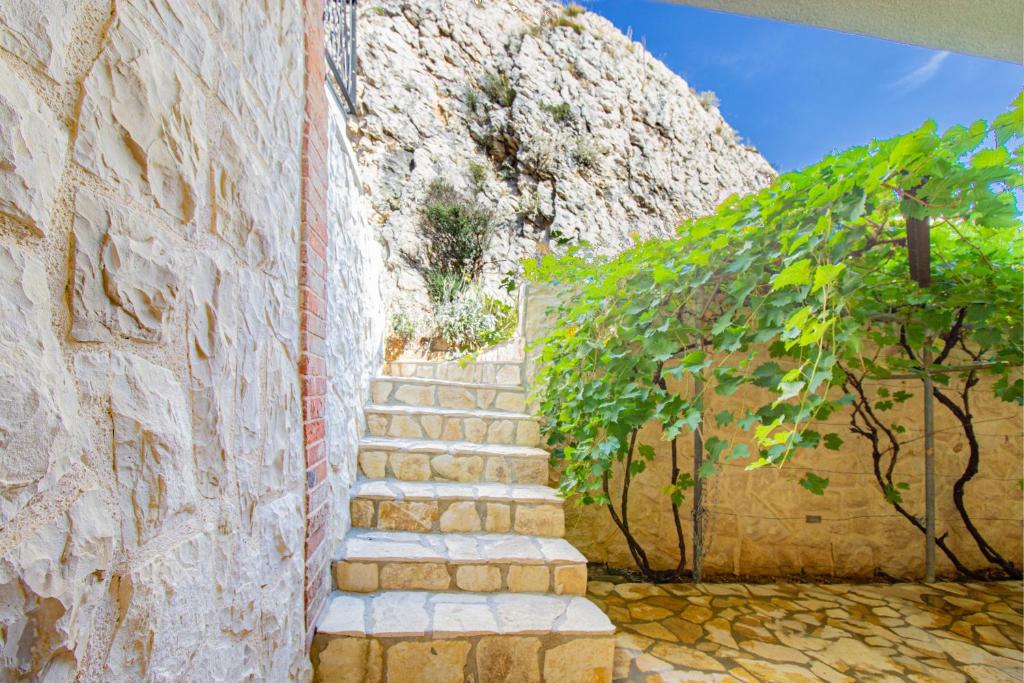 a stairway leading up to a stone wall with a tree at Toncica Sunny terrace with seaview and shaded BBQ area in Metajna