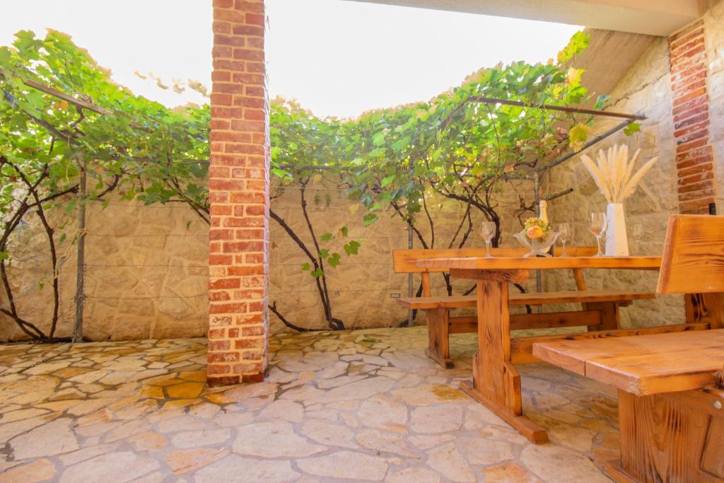 a patio with a wooden bench and a table at Toncica Sunny terrace with seaview and shaded BBQ area in Metajna